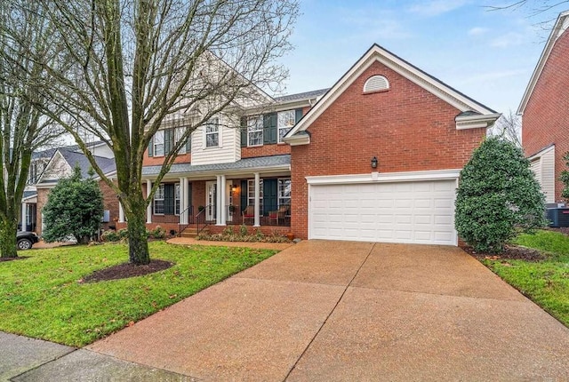 view of property with a garage, covered porch, and a front lawn