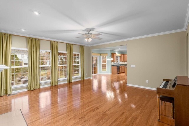 unfurnished living room featuring crown molding, ceiling fan, and light hardwood / wood-style flooring