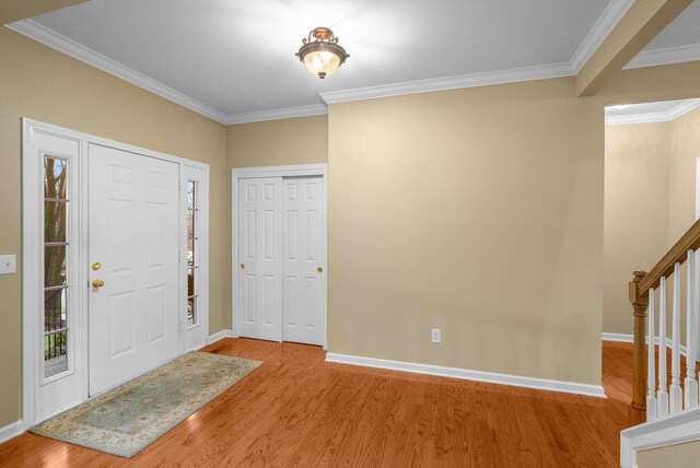 entryway featuring wood-type flooring and ornamental molding