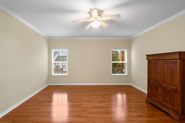 spare room featuring hardwood / wood-style flooring, ceiling fan, and crown molding