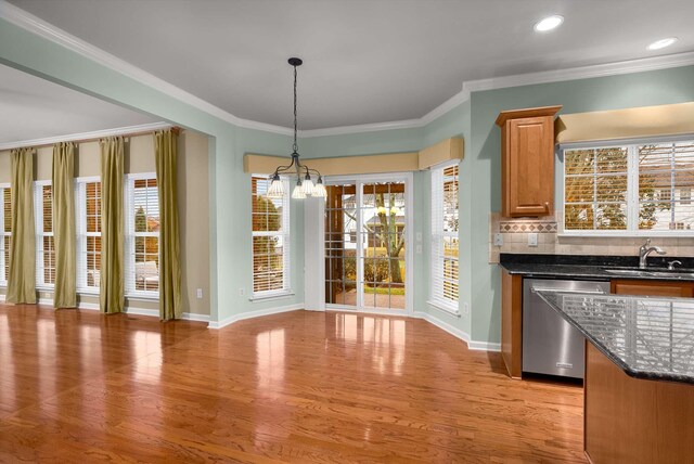 unfurnished dining area with crown molding, sink, and light wood-type flooring