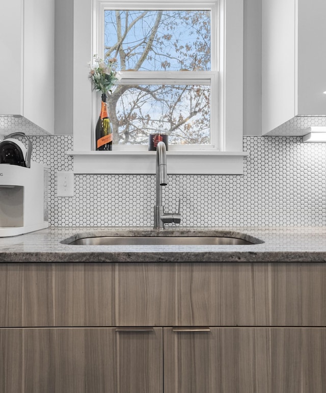 room details with white cabinetry, sink, and decorative backsplash