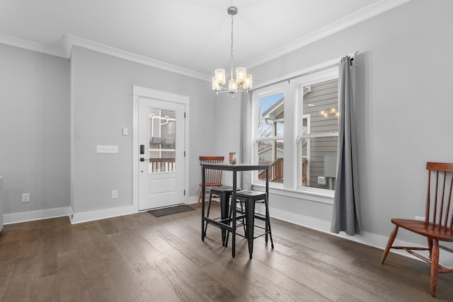 dining area with a notable chandelier, crown molding, and dark wood-type flooring