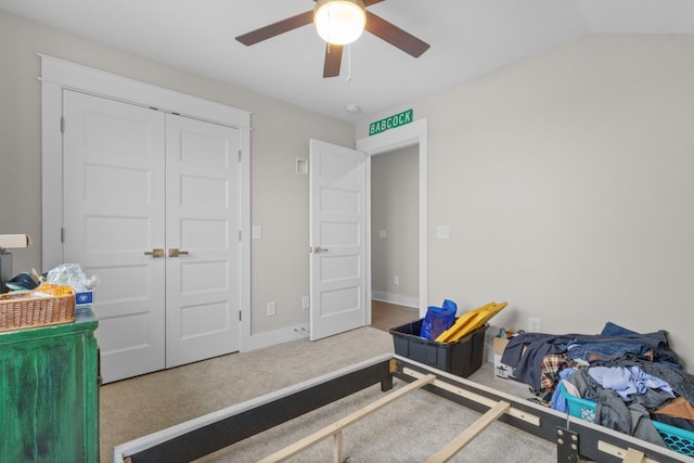 carpeted bedroom featuring ceiling fan, lofted ceiling, and a closet