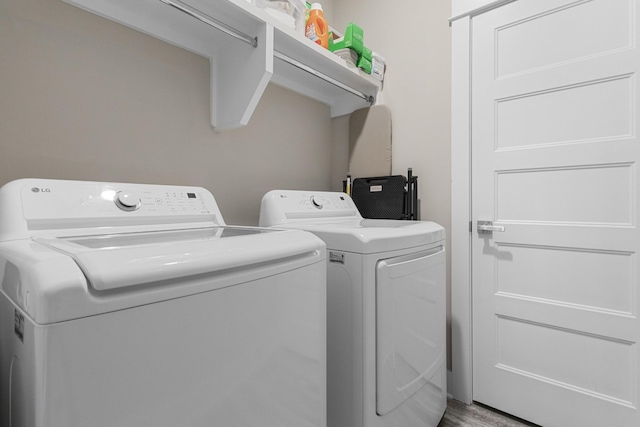 laundry room with washing machine and dryer and hardwood / wood-style floors