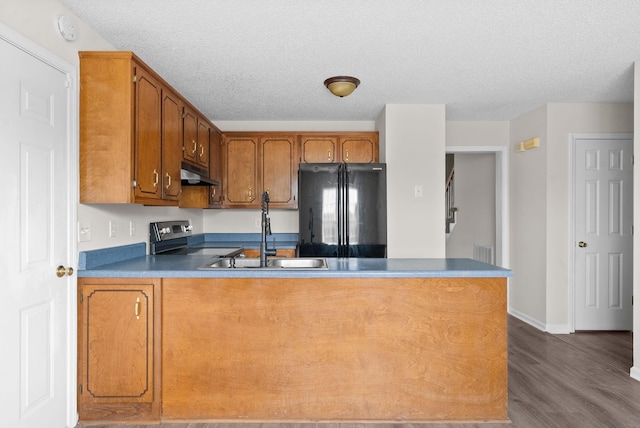 kitchen featuring sink, a textured ceiling, black fridge, dark hardwood / wood-style flooring, and stainless steel electric stove