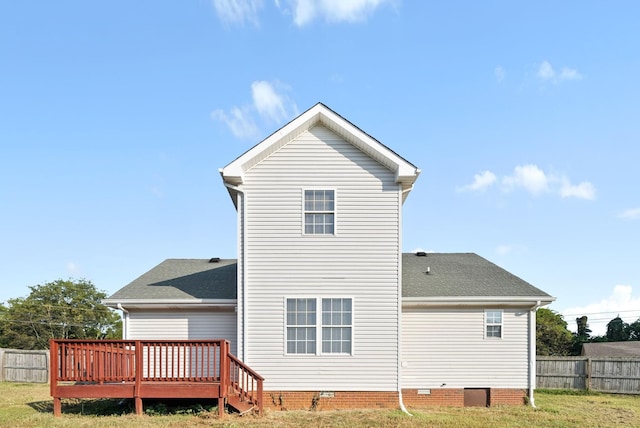 back of property featuring a wooden deck and a lawn