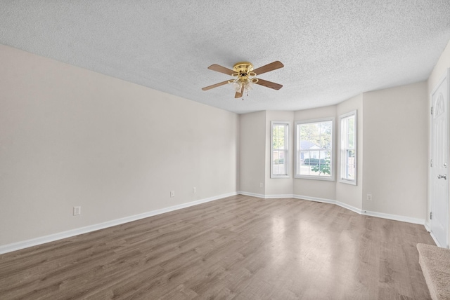 spare room with ceiling fan, wood-type flooring, and a textured ceiling