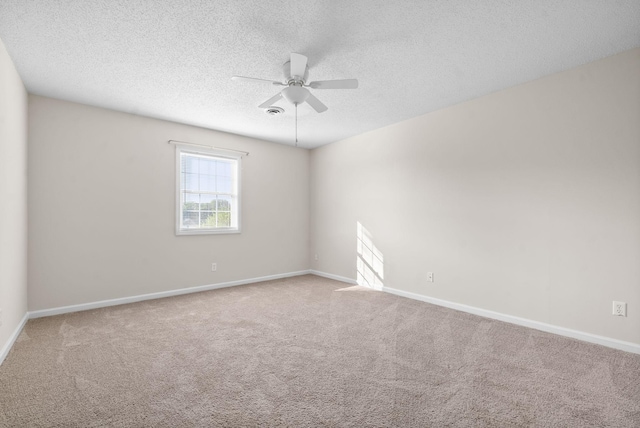 carpeted empty room with ceiling fan and a textured ceiling