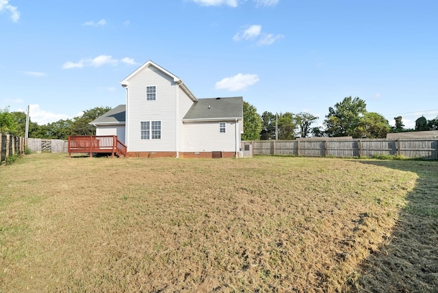 back of property with a wooden deck and a lawn