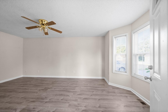 unfurnished room featuring ceiling fan, light hardwood / wood-style flooring, and a textured ceiling