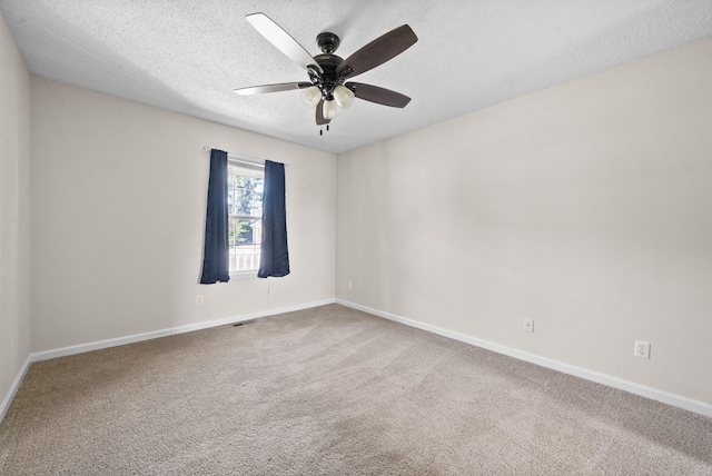 empty room featuring ceiling fan, carpet, and a textured ceiling