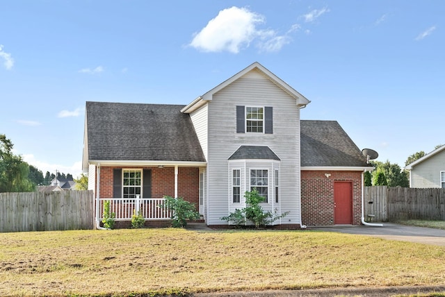 front facade with covered porch and a front yard