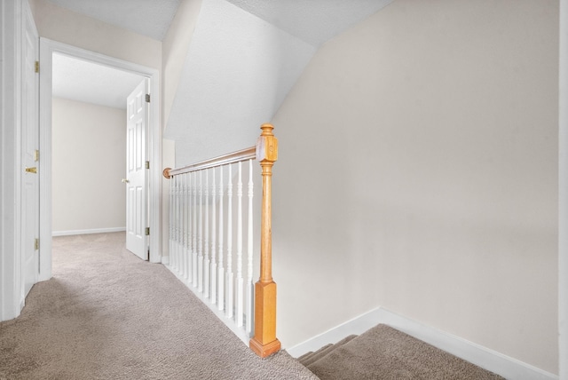 hallway featuring carpet flooring and vaulted ceiling