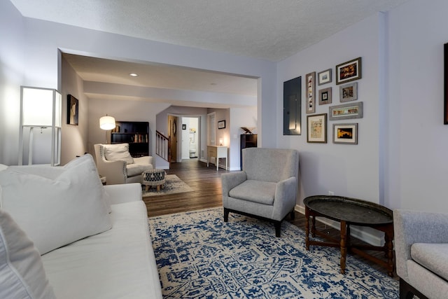 living room featuring electric panel, hardwood / wood-style floors, and a textured ceiling