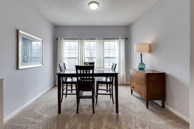 dining room with light carpet and a textured ceiling