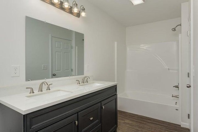 bathroom featuring  shower combination, hardwood / wood-style flooring, and vanity