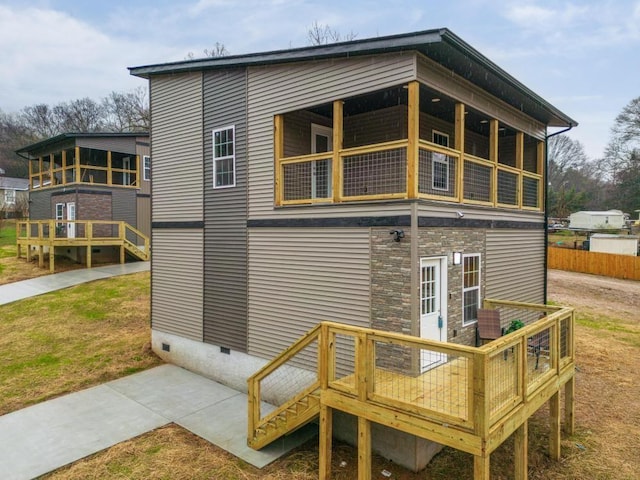 back of house with a lawn and a wooden deck