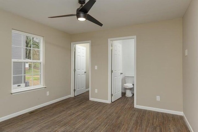 unfurnished bedroom with dark hardwood / wood-style flooring, ceiling fan, and connected bathroom