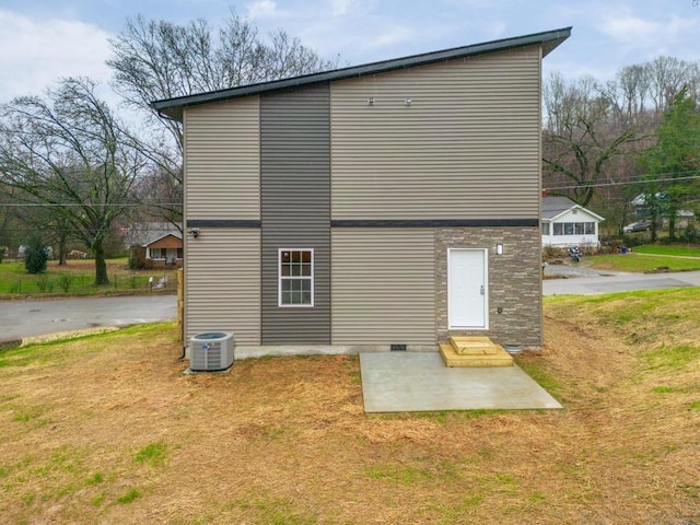 rear view of property with a patio, central air condition unit, and a yard