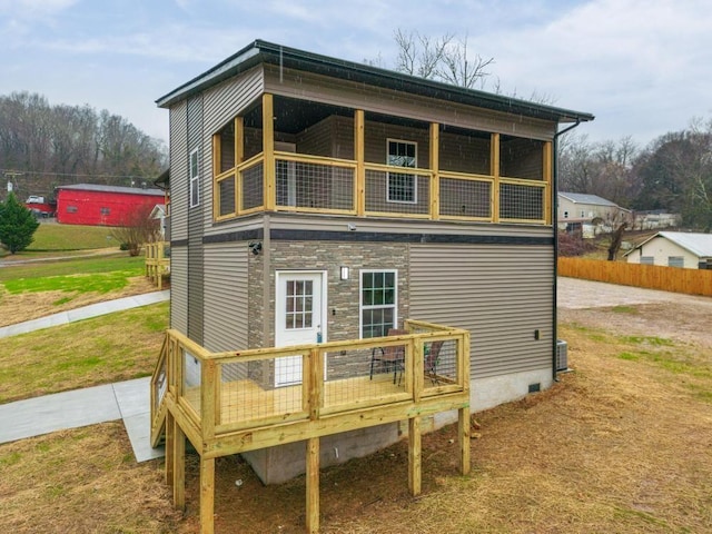 rear view of property featuring a yard and a wooden deck