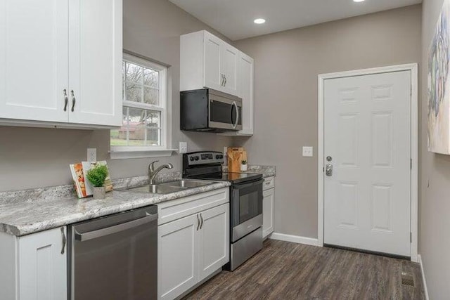 kitchen featuring appliances with stainless steel finishes, sink, white cabinetry, and dark hardwood / wood-style flooring