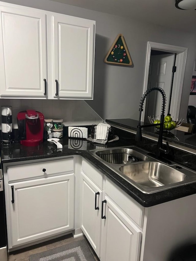 kitchen with white cabinetry, sink, and backsplash