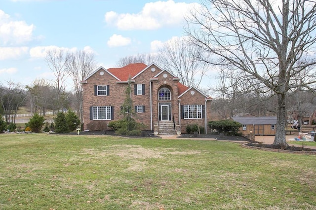 traditional-style house featuring a front yard and brick siding