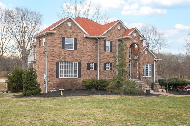 traditional-style house featuring brick siding and a front yard