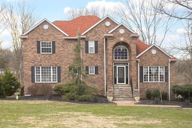 traditional home featuring brick siding and a front lawn