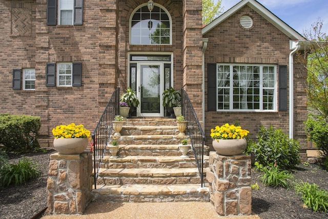 view of exterior entry featuring brick siding