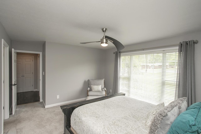 bedroom with ceiling fan, baseboards, and light carpet
