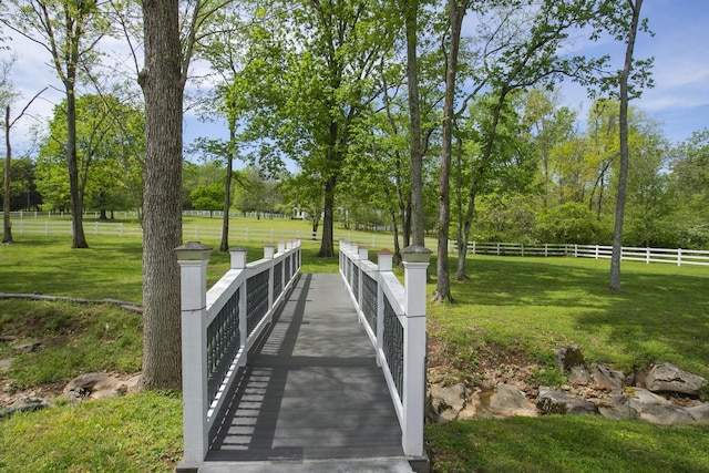view of home's community with a lawn and fence