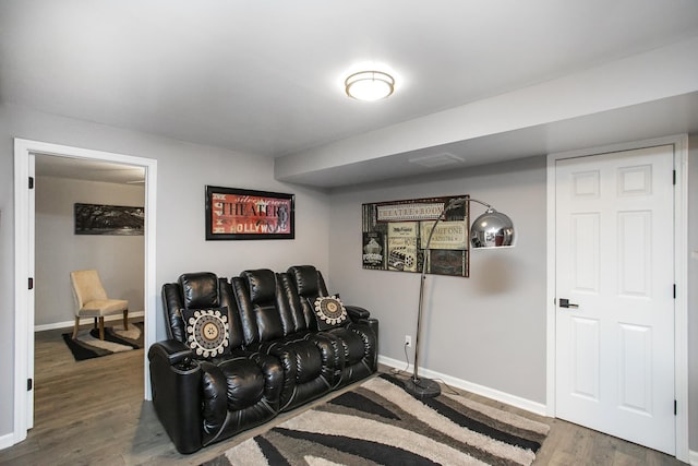 living area with baseboards and wood finished floors