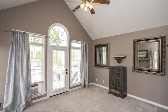 doorway with a ceiling fan, high vaulted ceiling, baseboards, and light carpet