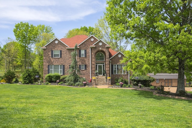 view of front of property featuring a front lawn and brick siding