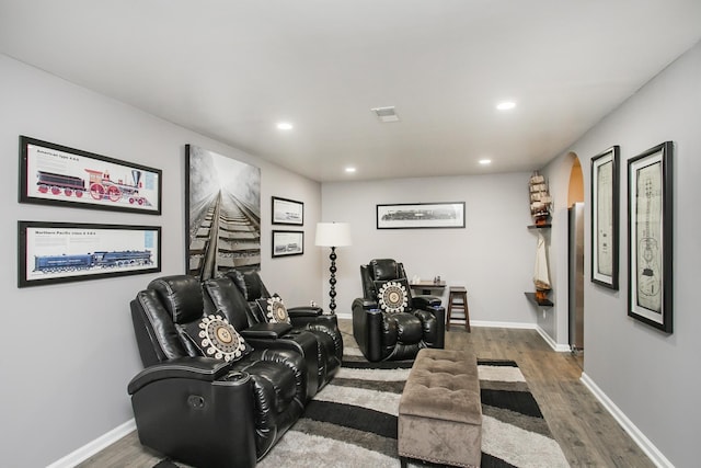 cinema with baseboards, recessed lighting, wood finished floors, and arched walkways