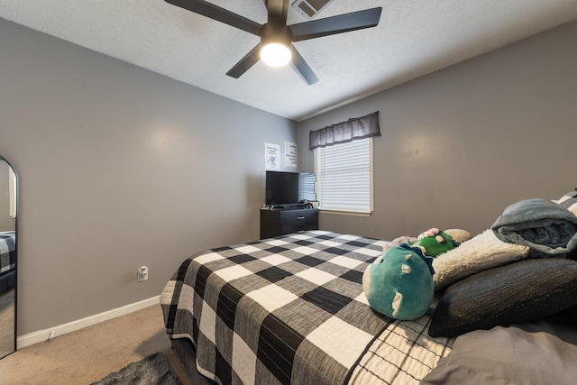 carpeted bedroom with ceiling fan and a textured ceiling