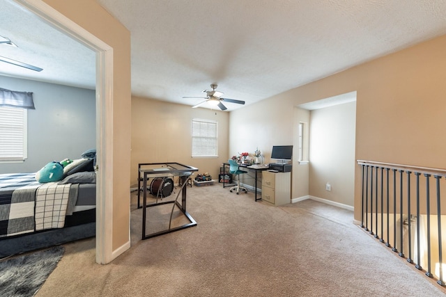 office area with ceiling fan, light colored carpet, and a textured ceiling