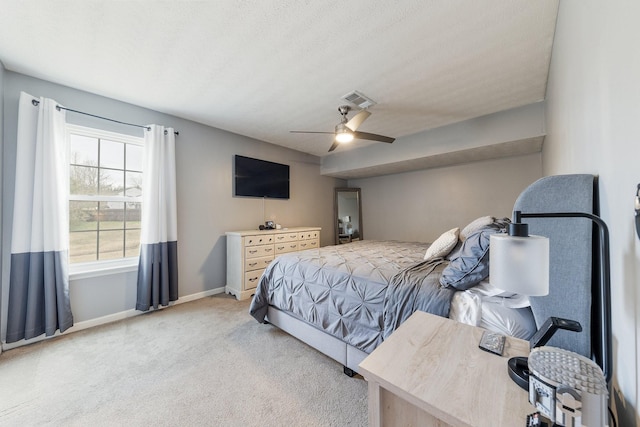 bedroom featuring light carpet, a textured ceiling, and ceiling fan