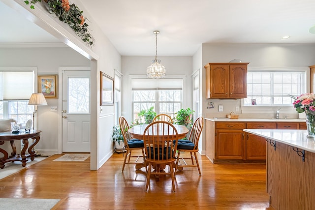 dining room featuring sink, an inviting chandelier, plenty of natural light, and light hardwood / wood-style flooring