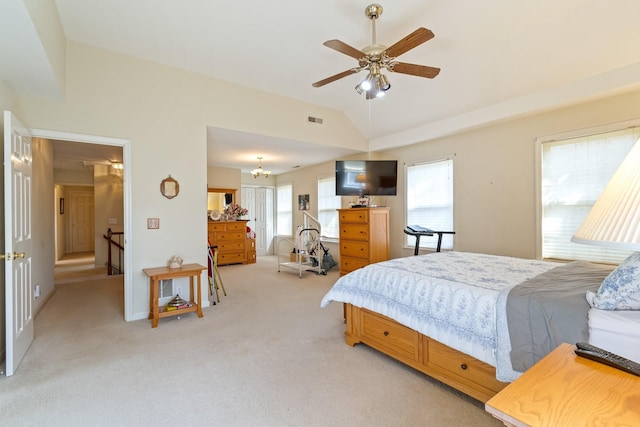 carpeted bedroom featuring ceiling fan with notable chandelier and vaulted ceiling