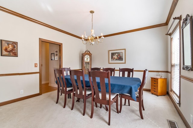 dining room with a notable chandelier, light colored carpet, and ornamental molding