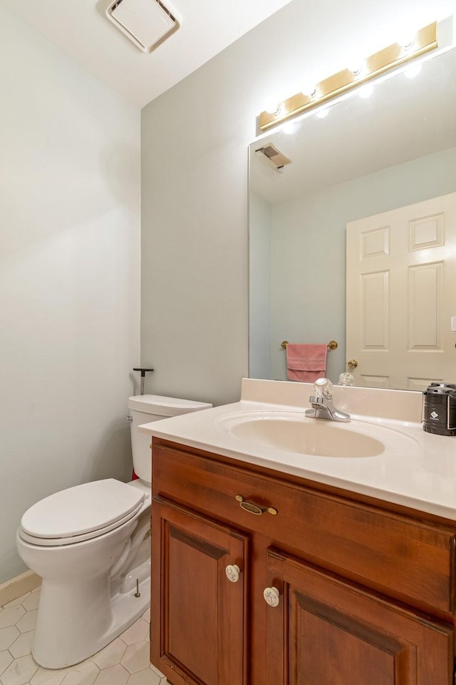 bathroom with toilet, tile patterned floors, and vanity