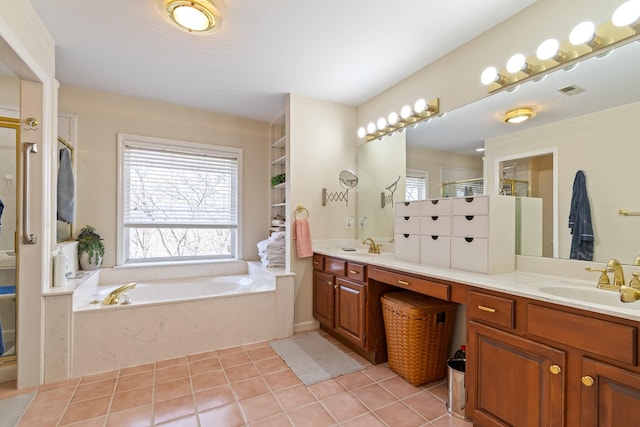 bathroom with tile patterned floors, a tub, vanity, and plenty of natural light