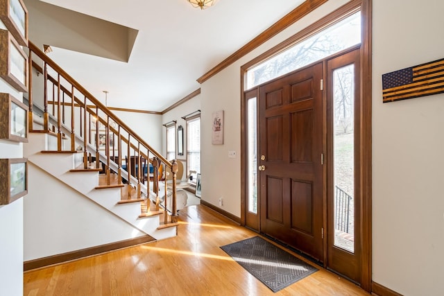 foyer entrance featuring light wood-type flooring and ornamental molding