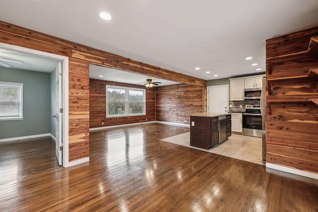 kitchen with appliances with stainless steel finishes, a center island, light hardwood / wood-style floors, and white cabinets