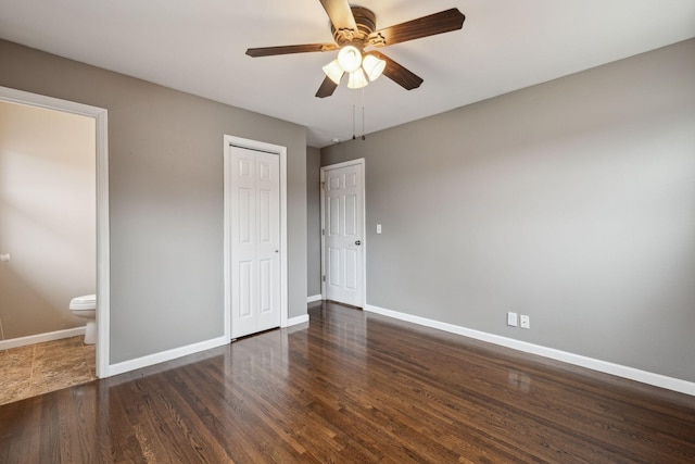 unfurnished bedroom featuring dark wood-type flooring, connected bathroom, ceiling fan, and a closet