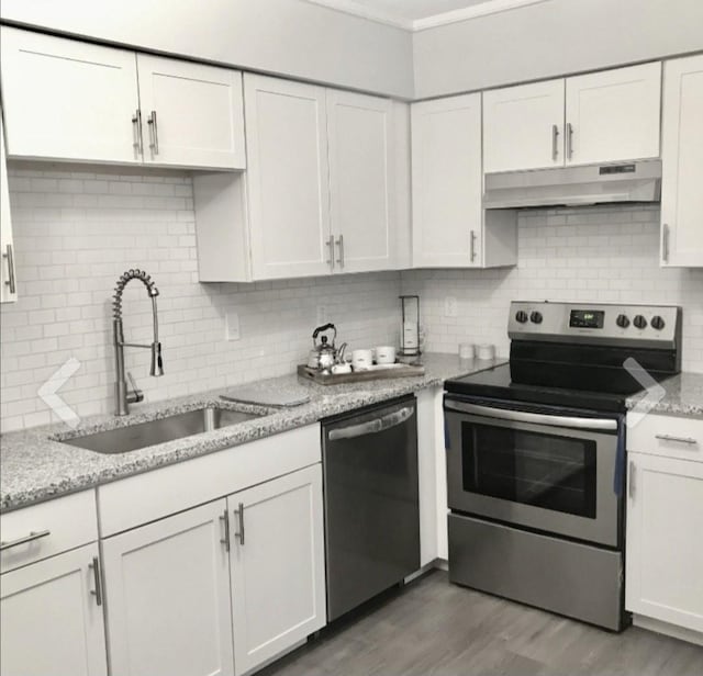 kitchen featuring white cabinetry, appliances with stainless steel finishes, light stone countertops, and sink