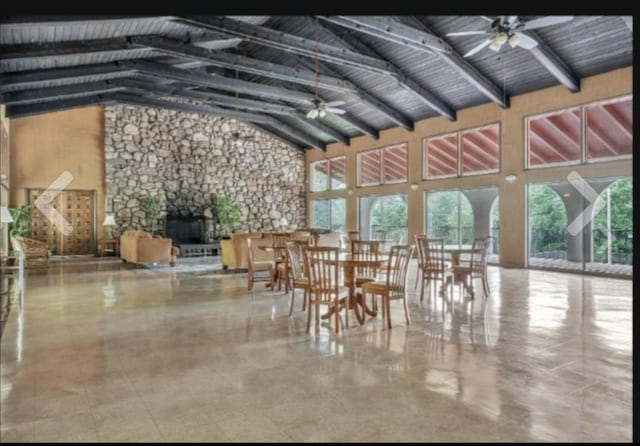 unfurnished sunroom with lofted ceiling with beams, a wealth of natural light, and ceiling fan